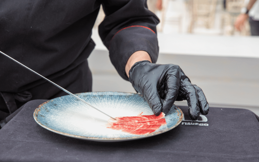 Cortador de jamón profesional en evento gastronómico empresarial